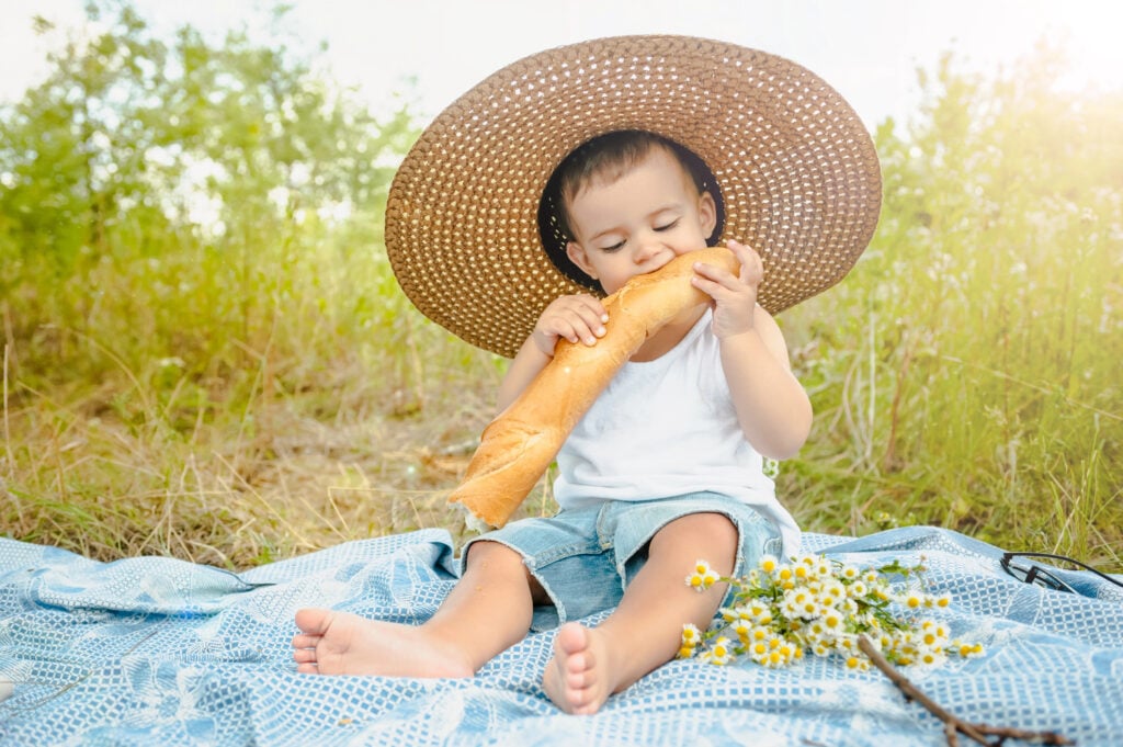 Baby eating bread outside