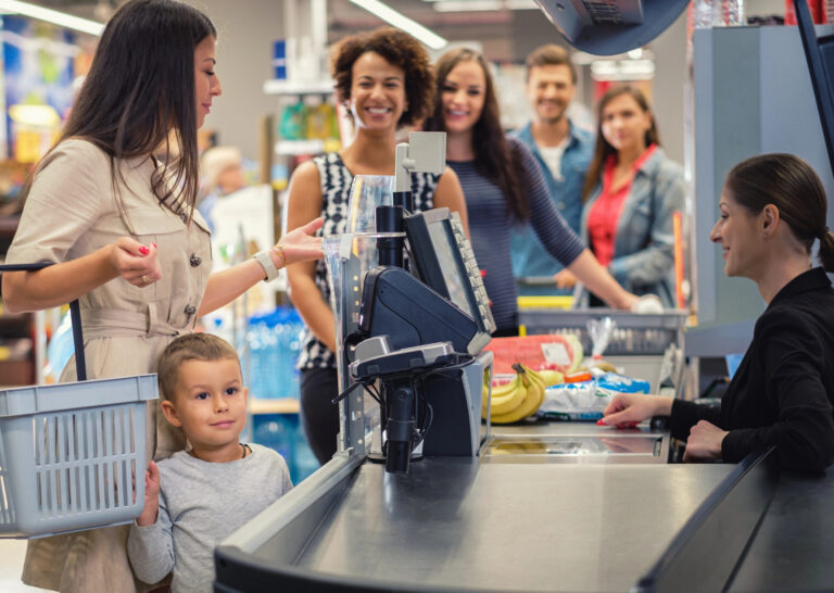 Woman is paying for groceries with a child beside her