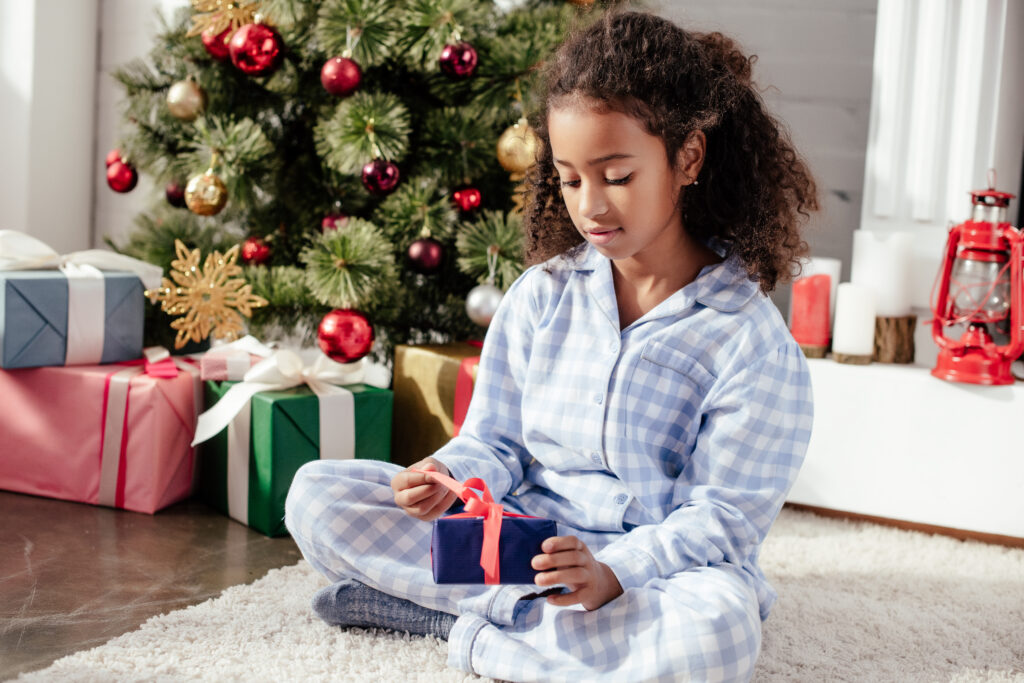 Girl opens presents in comfortable pajamas