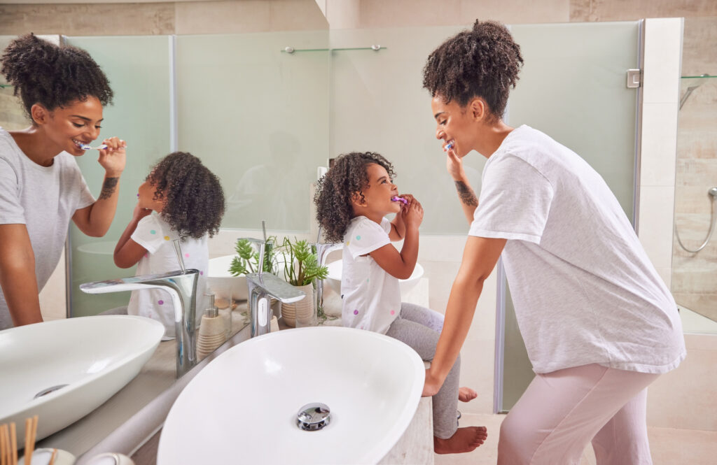 Mom  brushes teeth with child for company