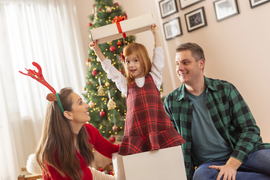 Parents with child in gift box at Christmas