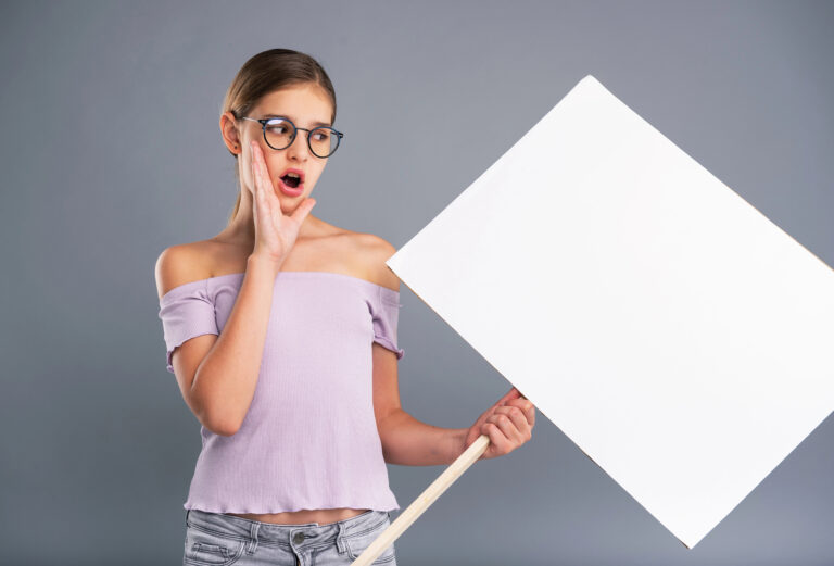 Pleasant teenage girl holding a banner and shouting